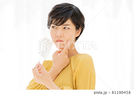 白いカーテンの前でマスクによる肌荒れに悩む若い女性 白いカーテンの前でマスクによる肌荒れに悩む若い女性 81190458