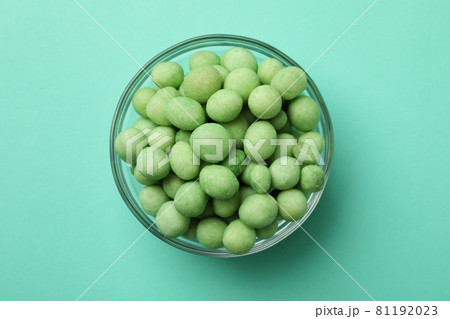 Bowl of wasabi nuts on mint background Bowl of wasabi nuts on mint background 81192023
