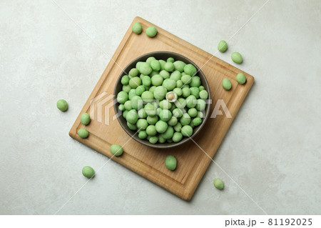 Board with bowl of wasabi nuts on white textured background Board with bowl of wasabi nuts on white textured background 81192025