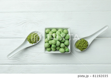 Tasty wasabi nuts and sauce on white wooden background 81192035