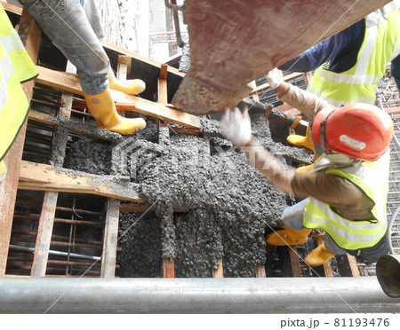 SELANGOR, MALAYSIA -AUGUST 01, 2016: Group of construction workers pouring wet concrete using concrete bucket into the timber form work at the construction site.   81193476