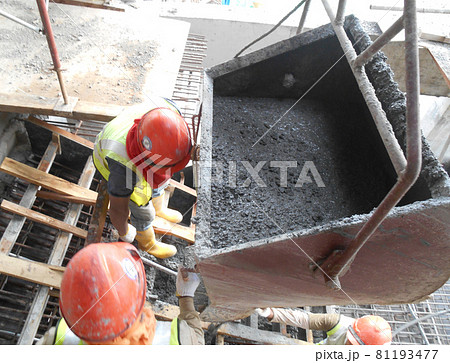 SELANGOR, MALAYSIA -AUGUST 01, 2016: Group of construction workers pouring wet concrete using concrete bucket into the timber form work at the construction site.   81193477