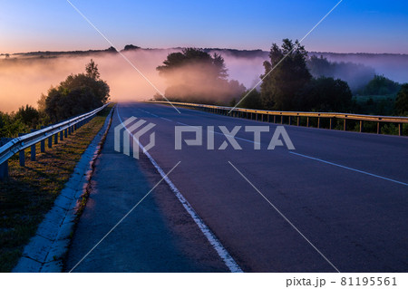 dence early morning fog in wold at summer highway near river with guard rails dence early morning fog in wold at summer highway near river with guard rails 81195561