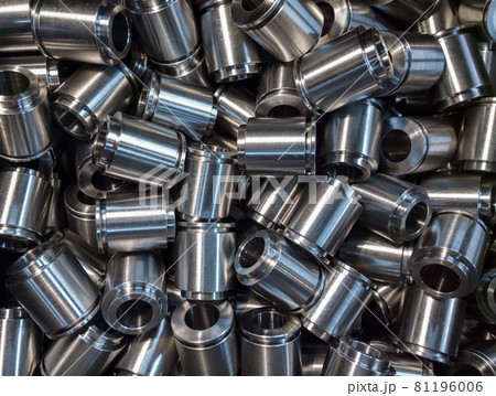 A lot of small equal shiny steel parts flat background. Raw metal surface after cnc turning light like silver 81196006