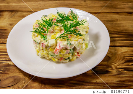 Salad with crab sticks, sweet corn, cucumber, eggs and mayonnaise on wooden table Salad with crab sticks, sweet corn, cucumber, eggs and mayonnaise on wooden table 81196771