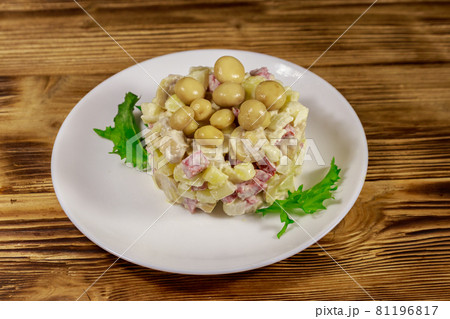 Potato salad with marinated mushrooms, sausage, onion and mayonnaise on wooden table 81196817