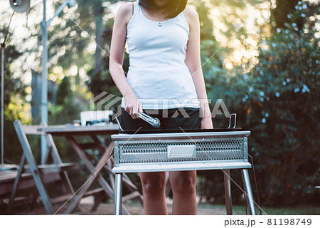 Woman using BBQ grill metal stainless stove and equipment at outdoor 81198749