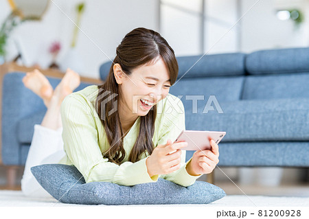 スマホで動画を見る若い女性 スマホで動画を見る若い女性 81200928