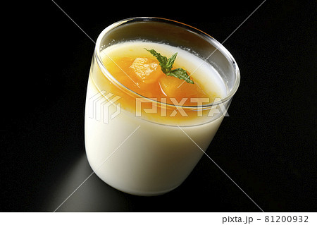 果肉入りのマンゴーソースがかかった杏仁豆腐を黒背景で撮影 81200932