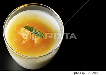 果肉入りのマンゴーソースがかかった杏仁豆腐を黒背景で俯瞰撮影 果肉入りのマンゴーソースがかかった杏仁豆腐を黒背景で俯瞰撮影 81200958