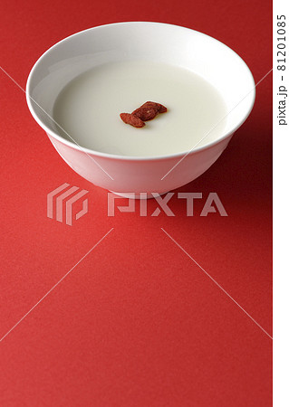 クコの実が乗っているシンプルな杏仁豆腐を赤色の背景で撮影 81201085