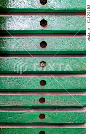 A stack of green, metal weights. A stack of green, metal weights. 81203562