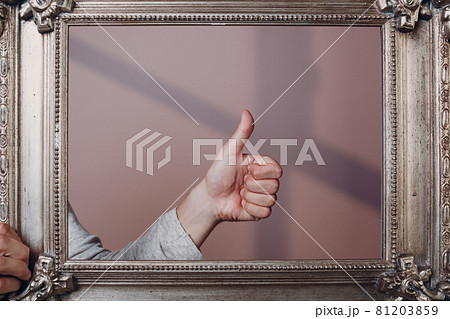 Thumbs up young man standing with picture frame at studio. Thumbs up young man standing with picture frame at studio. 81203859