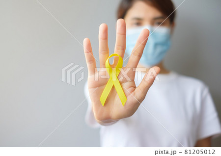 hand holding Yellow Ribbon for supporting people living and illness. September Suicide prevention day, Childhood, Sarcoma and bone cancer awareness month concept 81205012