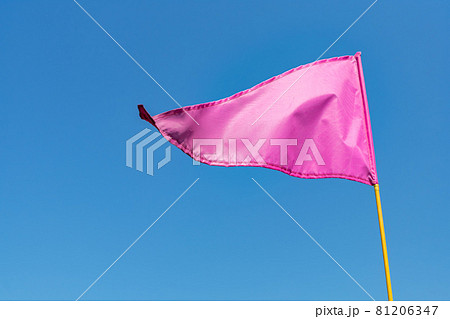 Pink flag waving in the wind against clear blue sky 81206347