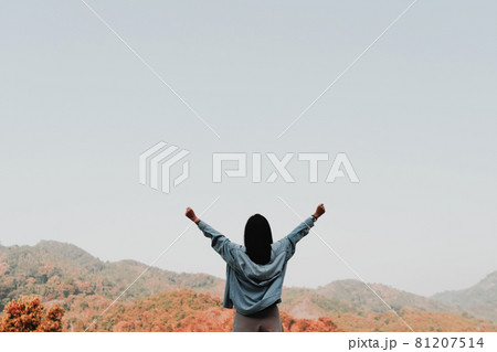 Woman rise hands up to sky freedom concept with blue sky and summer mountain background Woman rise hands up to sky freedom concept with blue sky and summer mountain background 81207514