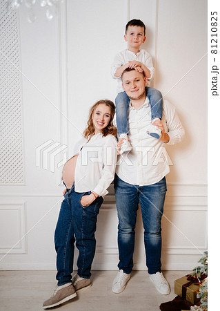 happy family. pregnant mother with her son and father in jeans and a white shirt 81210825