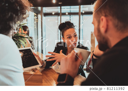 A group of friends hanging out in a cafe, and among them is a tablet. A group of friends hanging out in a cafe, and among them is a tablet. 81211392