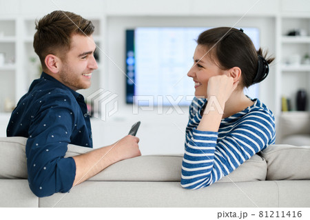 a young married couple enjoys sitting in the large living room 81211416