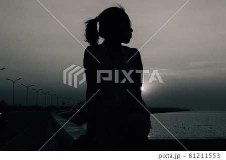 silhouette of a woman with the beautiful sun set in the golden time. Black and white color silhouette of a woman with the beautiful sun set in the golden time. Black and white color 81211553