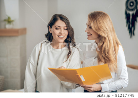 Young woman talking with a real estate agent about renting an apartment and looking involved Young woman talking with a real estate agent about renting an apartment and looking involved 81217749