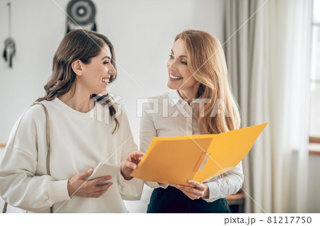 Young woman talking with a real estate agent about renting an apartment and looking involved Young woman talking with a real estate agent about renting an apartment and looking involved 81217750