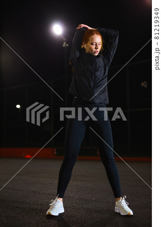 Confident sportswoman is stretching arms before training workout outdoors 81219349