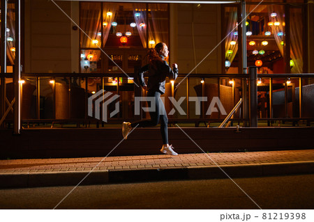 side view on sportive female running past city cafe at night, cardio training side view on sportive female running past city cafe at night, cardio training 81219398