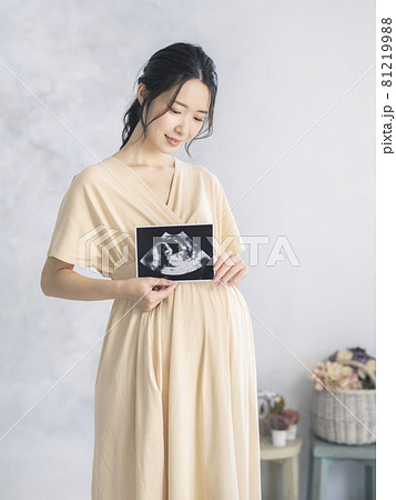 エコー写真を持つ妊婦イメージ　マタニティフォト　 81219988