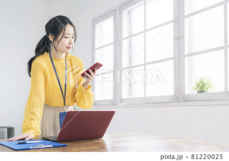 カジュアルなオフィスでスマホを使う女性 ビジネスウーマン カジュアルなオフィスでスマホを使う女性 ビジネスウーマン 81220025