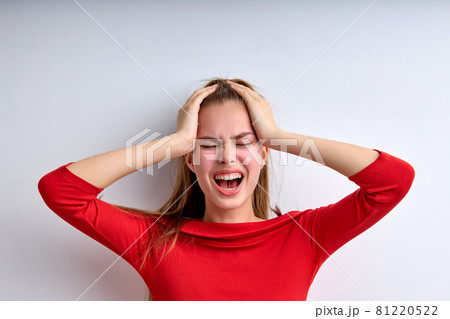 Desperate young teen girl screaming, depressed, female at a loss, touching head 81220522