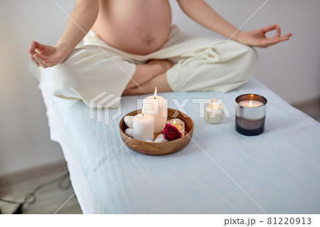 Cropped young pregnant woman sitting in yoga position in spa room, relaxing Cropped young pregnant woman sitting in yoga position in spa room, relaxing 81220913