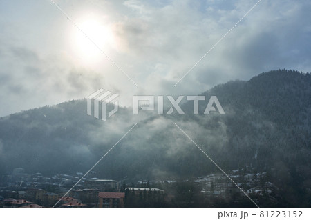 Winter mountain landscape. Small town between mountains. A cloud hangs over the city 81223152