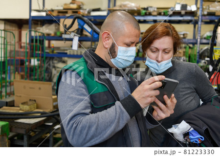 Industrial workers with face masks protected against corona virus discussing about production in factory. People working during COVID-19 pandemic. Industrial workers with face masks protected against corona virus discussing about production in factory. People working during COVID-19 pandemic. 81223330