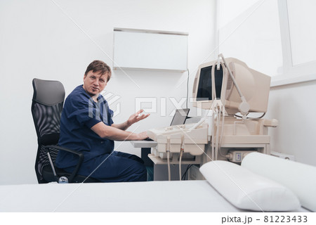 Orthopedist doctor examining X-ray picture at desk in clinic on laptop computer Orthopedist doctor examining X-ray picture at desk in clinic on laptop computer 81223433