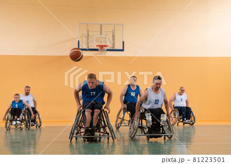 disabled war veterans in action while playing basketball on a basketball court with professional sports equipment for the disabled disabled war veterans in action while playing basketball on a basketball court with professional sports equipment for the disabled 81223501