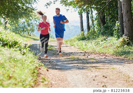 couple enjoying in a healthy lifestyle while jogging on a country road couple enjoying in a healthy lifestyle while jogging on a country road 81223638