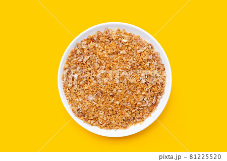 Fried minced garlic recipe in white plate on yellow background. 81225520