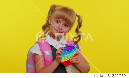 Joyful pupil girl playing with pop it sensory anti-stress toy kid presses on squishy bubbles game Joyful pupil girl playing with pop it sensory anti-stress toy kid presses on squishy bubbles game 81225779