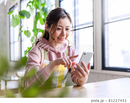 エプロン姿の女性とスマホ 81227431