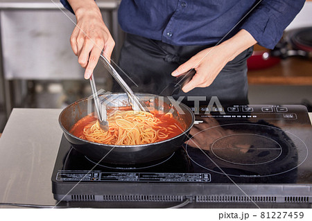 パスタを調理するエプロン姿の若い男性の手　料理男子イメージ 81227459
