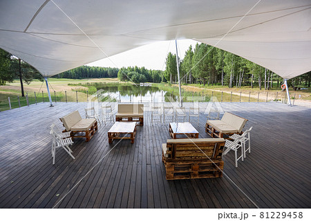 Wooden furniture in a tent in the middle of a green field 81229458