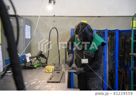 a woman working in the modern metal production and processing industry welding the product and prepares it for a cnc machine 81229559