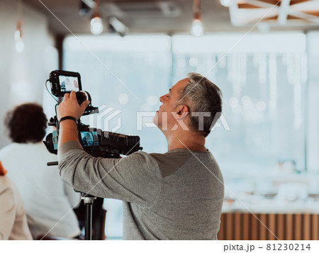 Cameraman working on professional camera taking stock footage 81230214