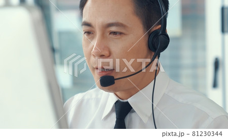 Businessman wearing headset working actively in office Businessman wearing headset working actively in office 81230344