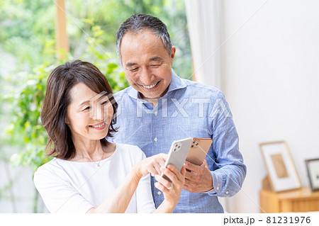 リビングでスマホを見るシニア夫婦 リビングでスマホを見るシニア夫婦 81231976