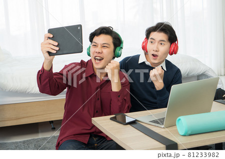 Two young man friends excited watching TV online 81233982