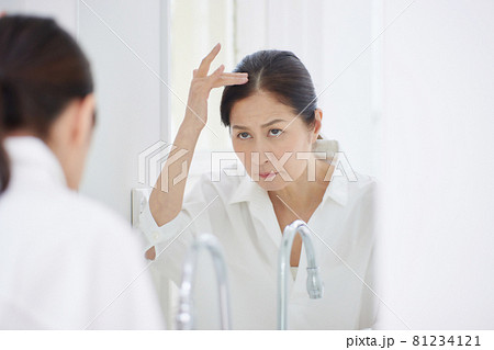 髪の毛を気にするシニアの女性 81234121