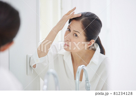 髪の毛を気にするシニアの女性 81234128