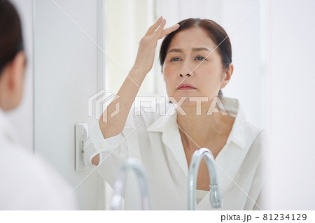 髪の毛を気にするシニアの女性 81234129